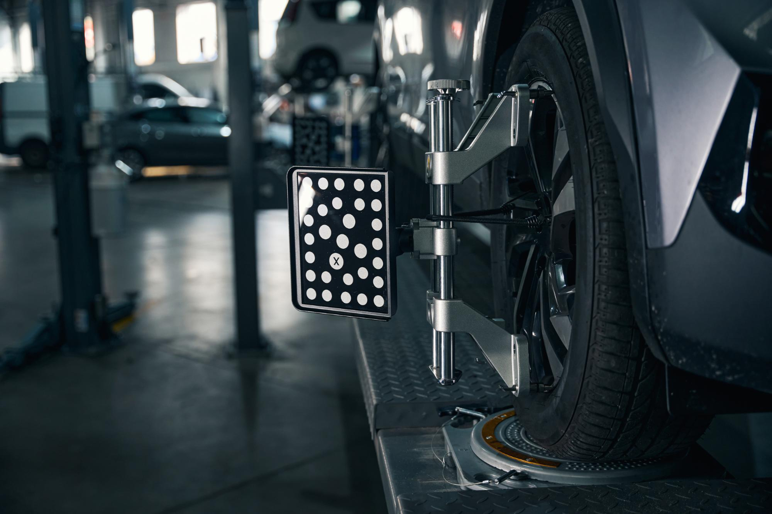 ALT-TEXT: Alignment rack with laser sensors attached to all four wheels.