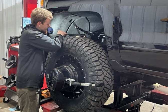 Technician adjusting front toe angle on a modern vehicle.