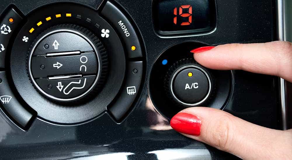 image of someone turning the AC dial in their car